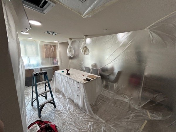 Wide view of kitchen containment with wrapped pendant lights and covered island