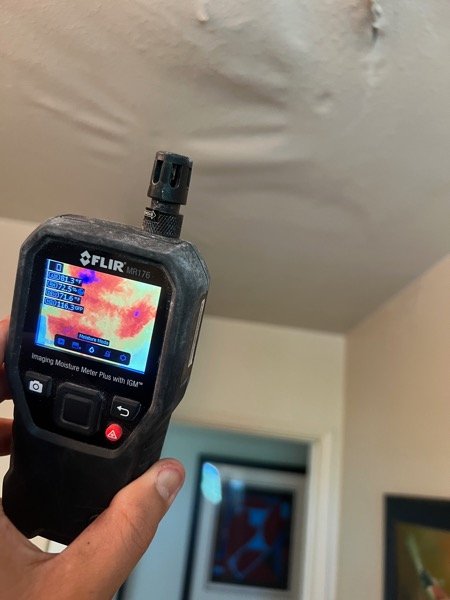 Thermal moisture meter checking a tiled shower wall
