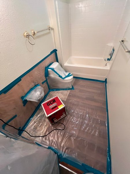 Floor containment and drying setup in a bathroom during mitigation