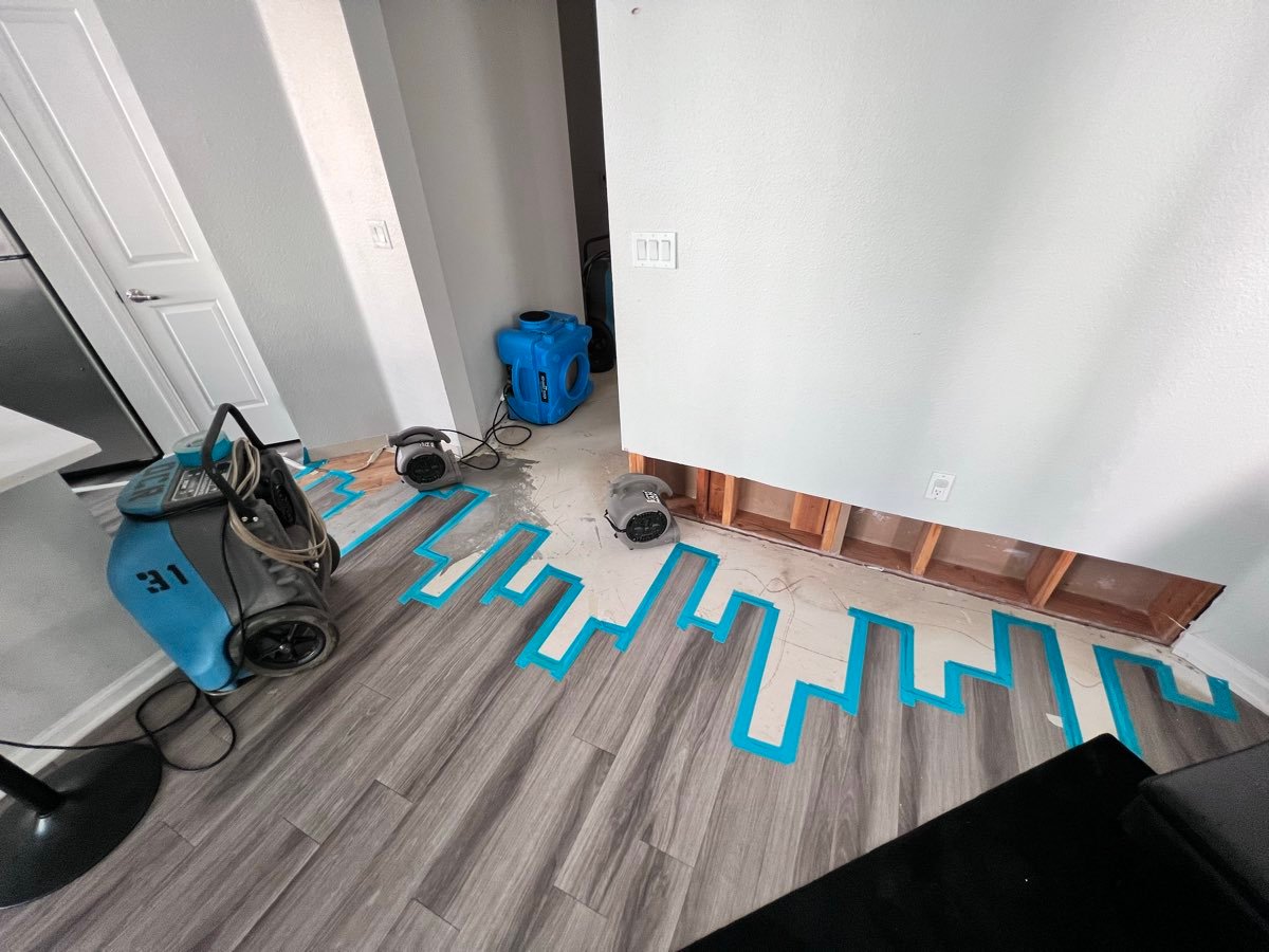 Air movers and floor drying mats used for emergency water extraction on a San Diego job site